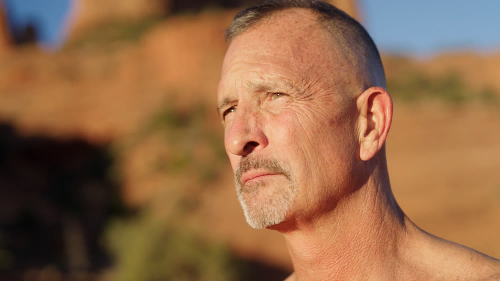 A builder photographed at golden hour, looking out over his site
